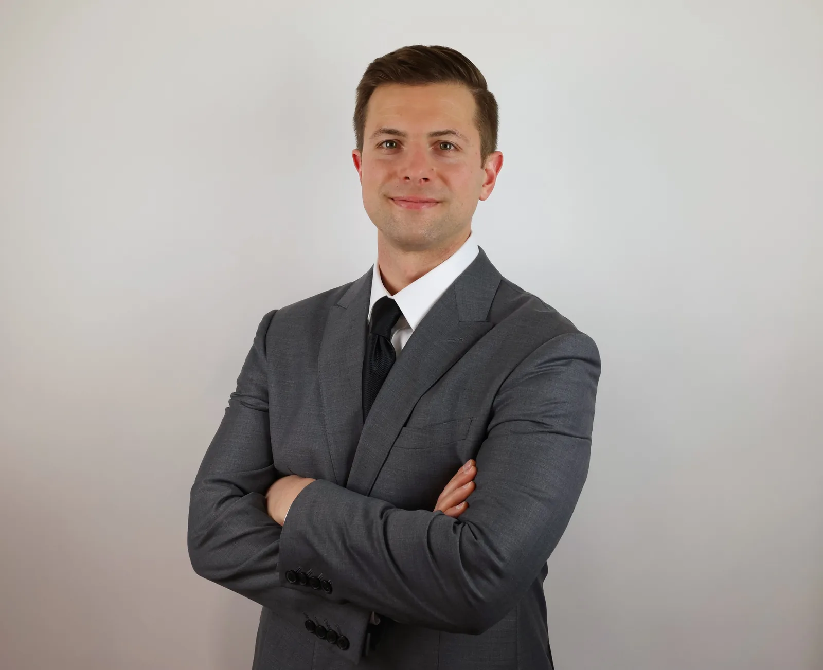 Professional studio portrait of a man in a gray suit